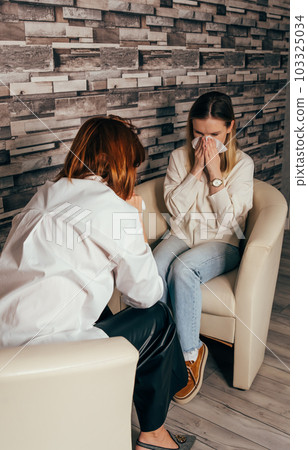 Unhappy young woman crying, wiping tears with handkerchief Unhappy young woman crying, wiping tears with handkerchief 103325034