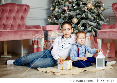 Family on Christmas eve near christmas tree. Holiday gatherings 103325042