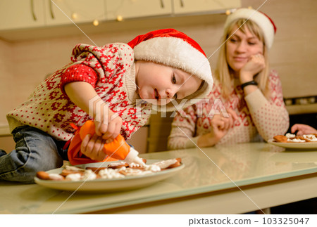 Santa kid making cookie for family in cozy kitchen. Santa helper 103325047