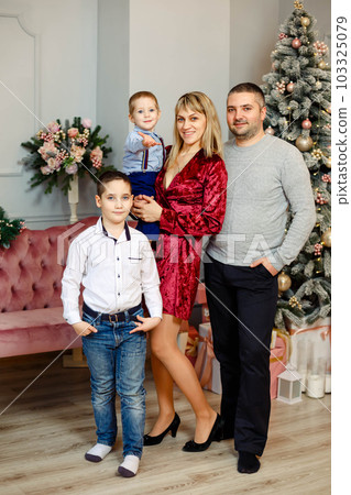 Smiling family is celebrating New Year together. Family open gifts 103325079