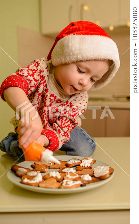 Happy boy in Santa Helper hats making cookies. Kid cooking cookies 103325080