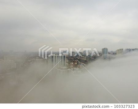 Foggy morning in the city buildings growing through the mist and fog  103327323