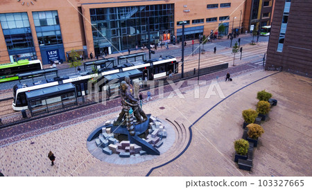 Funny sculpture in Odense and tram and people walking Funny sculpture in Odense and tram and people walking 103327665