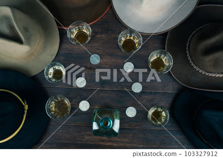 Bourbon shots with old west hats on table. Top view. 103327912