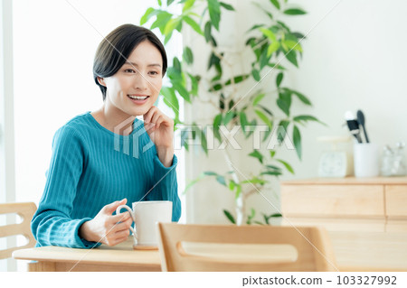 在客廳喝熱飲放鬆的女人 103327992