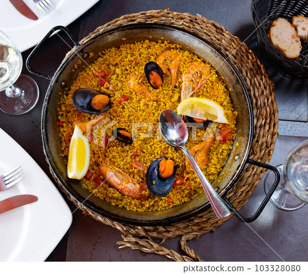 Spanish rice dish paella tinted with saffron. Prepared with olive oil and seafood 103328080