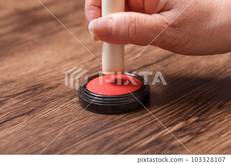 [Woman putting ink on seal] 103328107