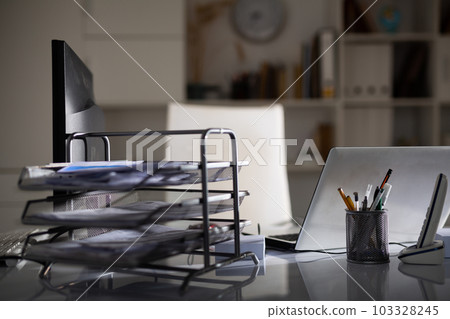 Workplace for two with laptop and desktop computer monitor in dark office Workplace for two with laptop and desktop computer monitor in dark office 103328245