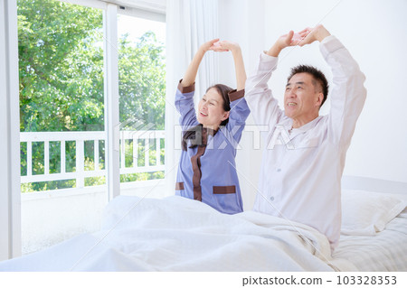 Senior couple stretching in the bedroom Senior couple stretching in the bedroom 103328353