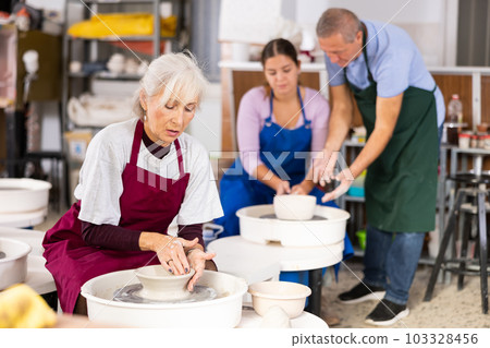lady works on potter's wheel lady works on potter's wheel 103328456