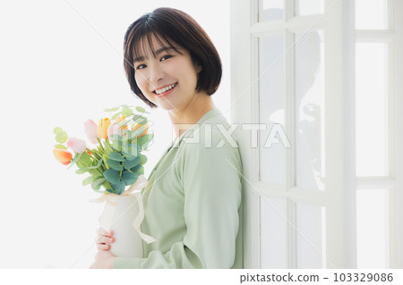 A woman holding a vase of tulips A woman holding a vase of tulips 103329086
