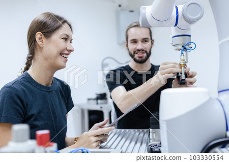 Male and female using tablet staff engineer with robot for education at class room. Male and female using tablet staff engineer with robot for education at class room. 103330554