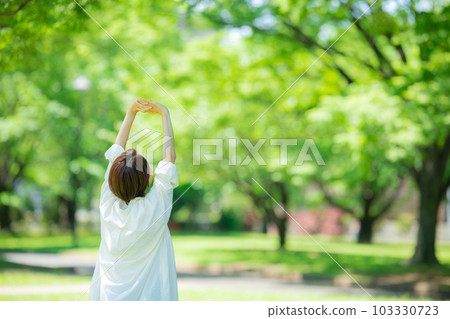 A woman stretching in a fresh green park A woman stretching in a fresh green park 103330723