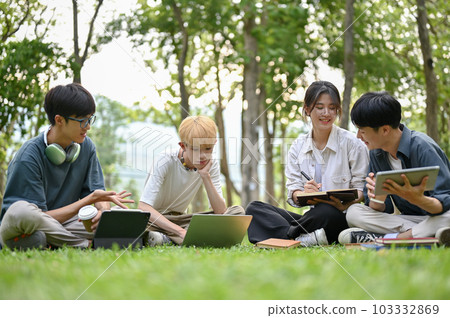 A group of diverse young Asian college students are doing a school project at the park together. A group of diverse young Asian college students are doing a school project at the park together. 103332869