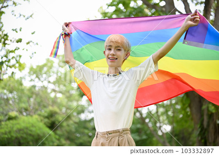 Portrait of a carefree and happy young Asian gay man with an LGBT rainbow flag Portrait of a carefree and happy young Asian gay man with an LGBT rainbow flag 103332897