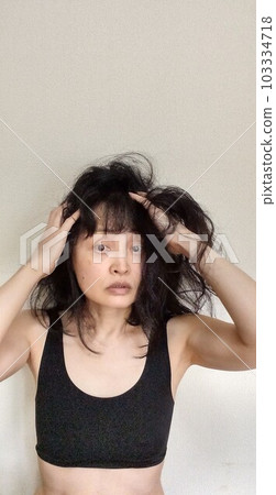 A Japanese woman whose hair is unmanageable due to humidity during the rainy season 103334718