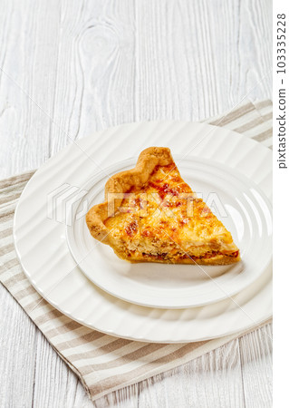 quiche with cheese and bacon filling on plate 103335228
