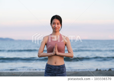 Portrait of a woman doing yoga on the beach in the evening Portrait of a woman doing yoga on the beach in the evening 103336570
