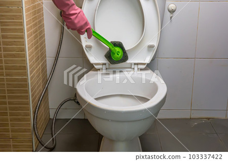 Woman cleaning toilet Woman cleaning toilet 103337422
