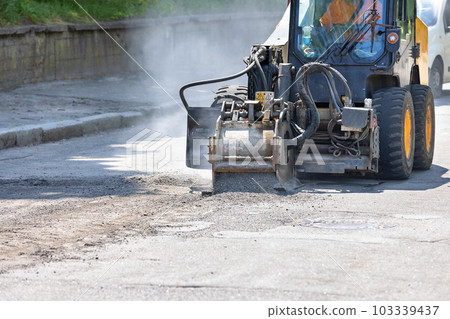 Industrial milling of the old asphalt pavement for the subsequent renovation of the roadway. 103339437