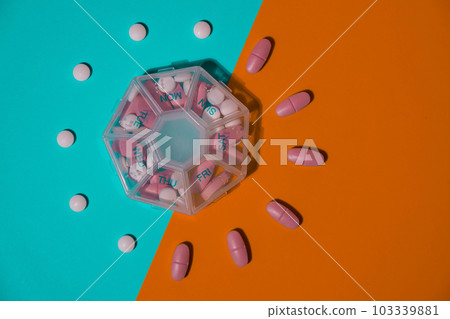 Organizer weekly shots medical pill box with doses of tablets for daily take medicine with white pink drugs and capsules. Copy space Daily vitamins at home. Health care and diseases cure 103339881