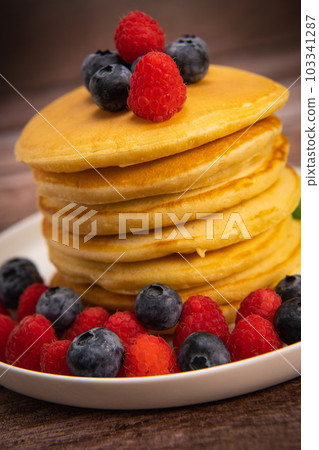 Recipe for maple syrup pancakes with raspberry and blueberry filling 103341287