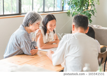 Elderly couple and elementary school children teaching grandchildren's homework at home dining Elderly couple and elementary school children teaching grandchildren's homework at home dining 103341531