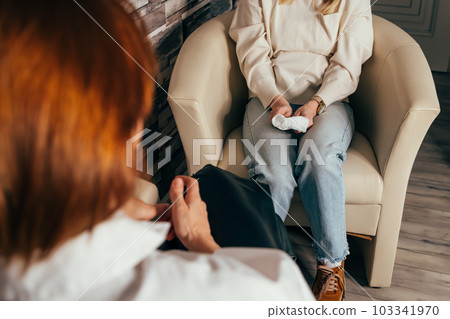 Psychotherapist taking notes during conversation with depressed female Psychotherapist taking notes during conversation with depressed female 103341970
