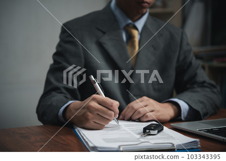 Businessman signing a contract for buying of selling a car.Car rental service. insurance, and contract agreement concepts 103343395