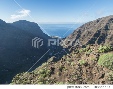 Aerial view from Mirador de la curva del queso. Green valley of Valle Gran Rey with mountain cliffs, ocean and colorful houses village with terraced fields. La Gomera, Canary island, Spain 103344383