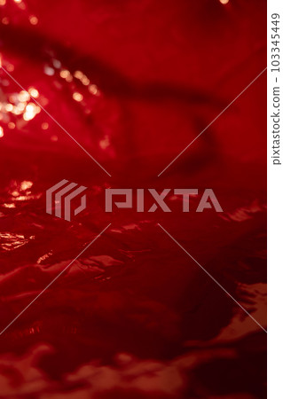Film texture red overlay. Creased wrap. Defocused bokeh light on shiny glowing wrinkled surface decorative abstract background with free space. 103345449