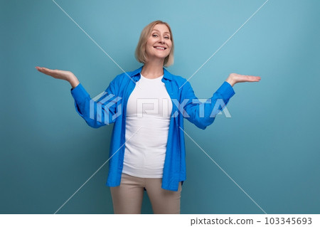 portrait of cheerful blonde 60s woman in casual stylish shirt with crossed arms on studio background portrait of cheerful blonde 60s woman in casual stylish shirt with crossed arms on studio background 103345693