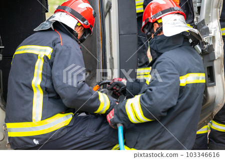 Firefighters using hydraulic tools during a rescue operation training. Rescuers unlock the passenger 103346616