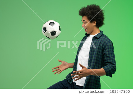 Young dark-skinned guy with a ball looking excited Young dark-skinned guy with a ball looking excited 103347500