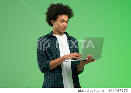 Young african american guy in checkered shirt with a laptop 103347575