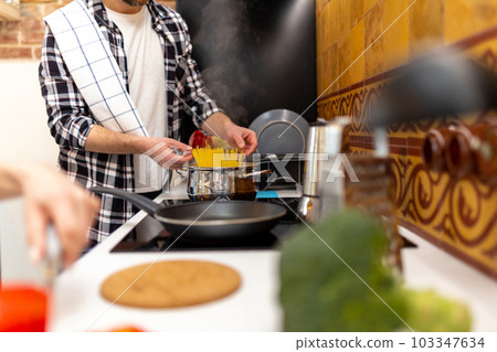 Couple preparing healthy meal in kitchenn enjoying cooking 103347634