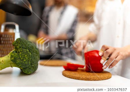 Young happy couple enjoying cooking together preparing healthy salad and pasta. Young happy couple enjoying cooking together preparing healthy salad and pasta. 103347637