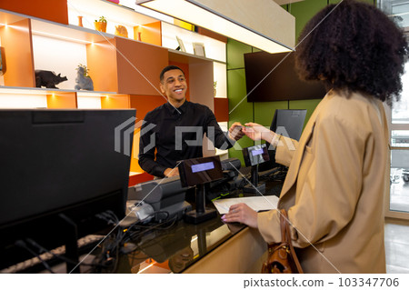 Receptionist helping a guest to check in 103347706