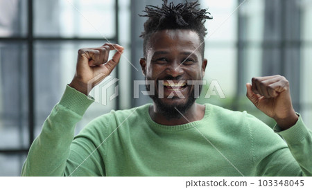 African man rejoices at the victory with his hands up African man rejoices at the victory with his hands up 103348045
