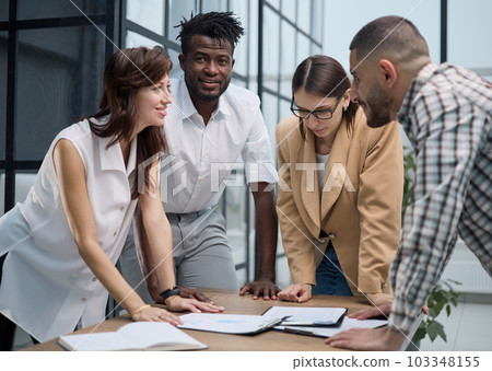 Cheerful colleagues discussing project in modern office Cheerful colleagues discussing project in modern office 103348155