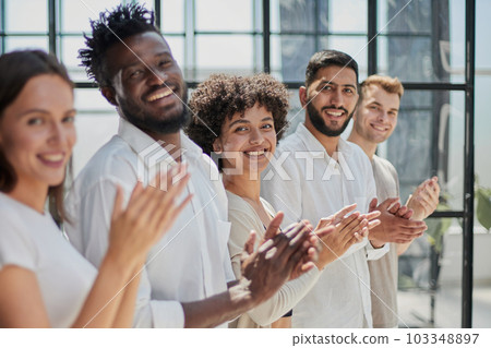 Group of businesspeople sitting in a line and applauding. 103348897