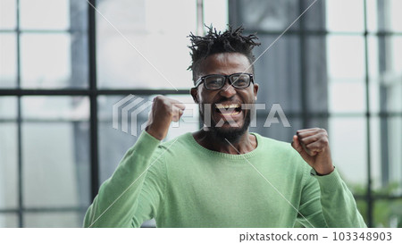 oyful bearded man in formal clothes, clenching his fists with happiness 103348903