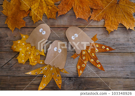 A child makes an octopus craft from autumn leaves and kraft paper. Step by step instruction 103348926