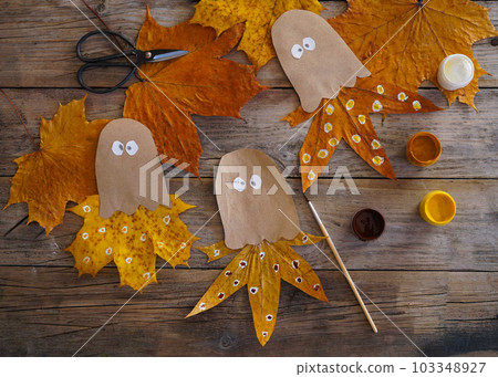 A child makes an octopus craft from autumn leaves and kraft paper. Step by step instruction - 4 103348927