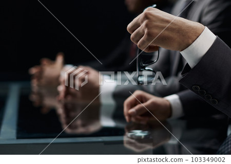 Close up of male hands holding a pair of glasses 103349002