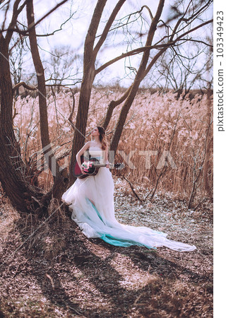Beautiful romantic european girl with guitar with flowers inside, posing outdoors. Concept of music and nature. Spring time. 103349423