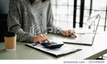 Businesswoman or accountant hand typing laptop working to calculate on desk about cost at home office. 103349694