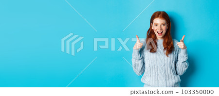 Cheerful teenage girl showing approval, make thumbs up and agree, liking something, standing over blue background Cheerful teenage girl showing approval, make thumbs up and agree, liking something, standing over blue background 103350000