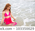 young girl sitting on the beach. by sea. tropical beach. summer style. 103350029