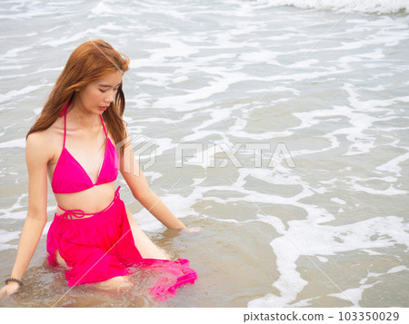 young girl sitting on the beach. by sea. tropical beach. summer style. 103350029